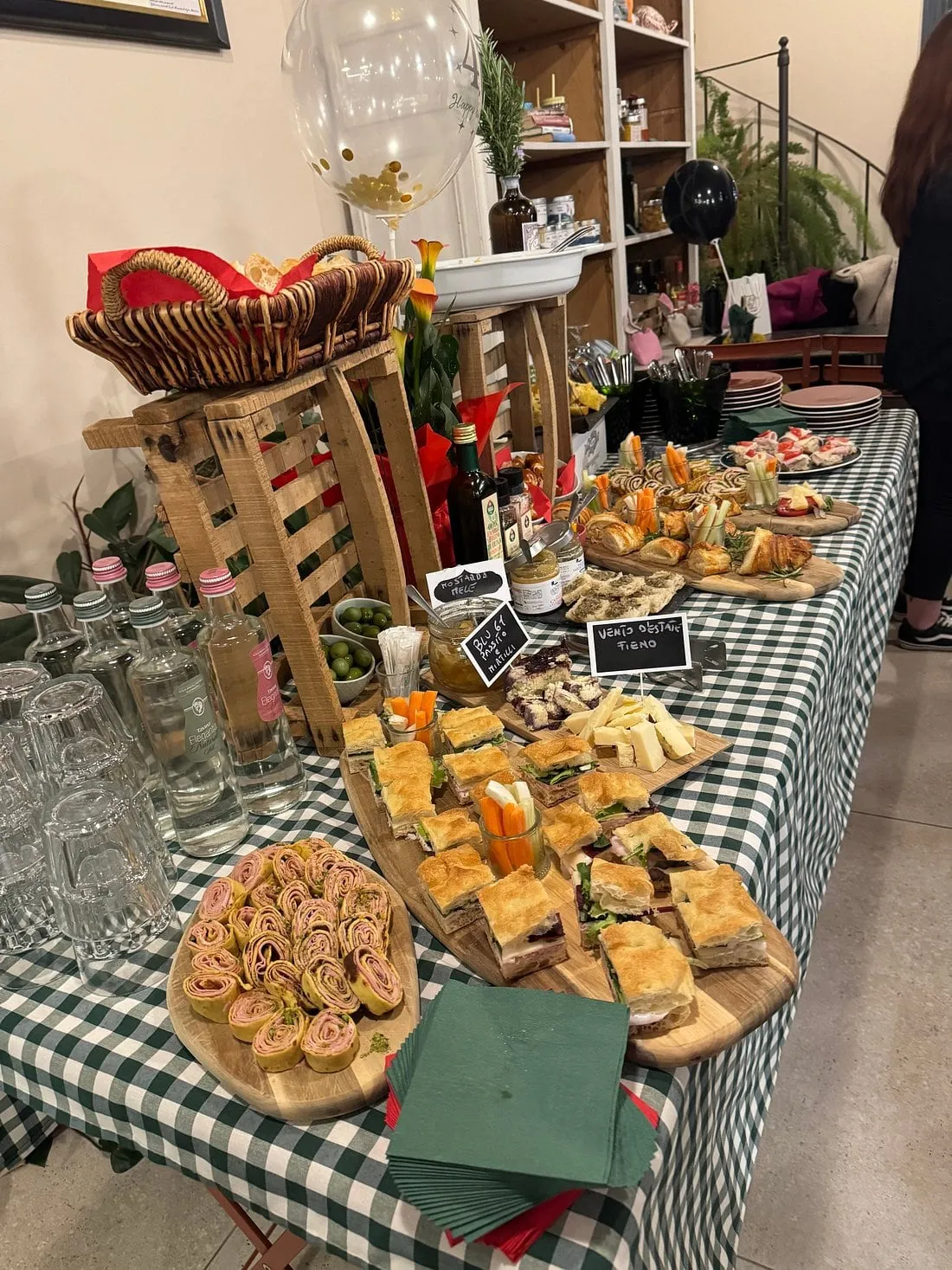 Un buffet per eventi privati all'Hortus: taglieri di focaccia, girelle salate e cestini su un tavolo a quadri verdi